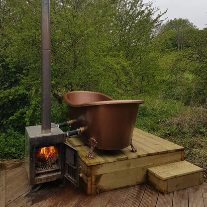 Coppersmith Creations Hammered Clawfoot Copper Bathtub Antique Finish Interior & Exterior 1680mm / 1830mm in outdoor on a wooden platform connected to a fireplace topview