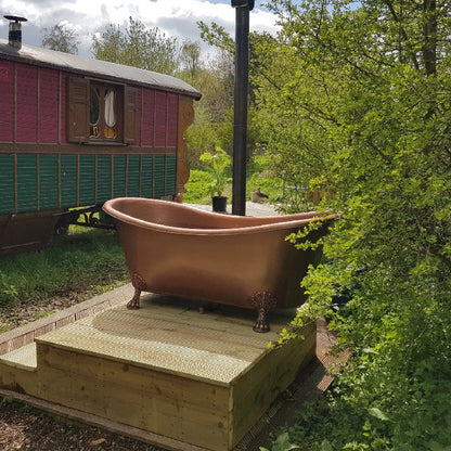 Coppersmith Creations Hammered Clawfoot Copper Bathtub Antique Finish Interior & Exterior 1680mm / 1830mm in outdoor setting surrounded it by trees