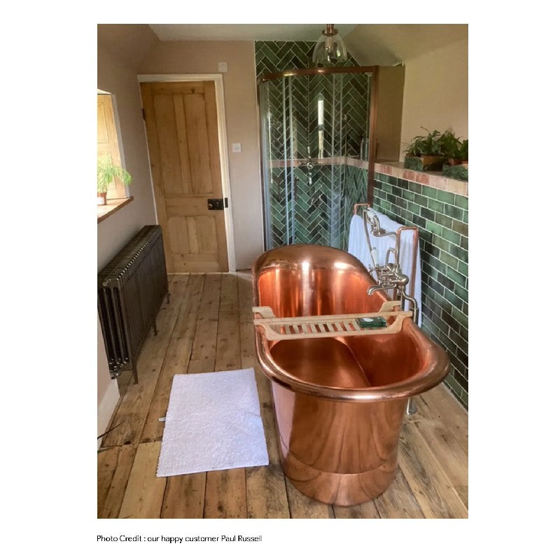 Coppersmith Creations Straight Base Copper Bathtub Full Polish Copper Finish 1700mm next to shower cubicle with green tiling and wooden floor