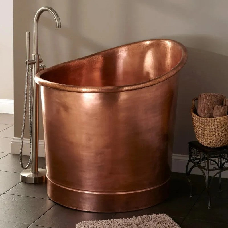 Coppersmith Creations 39-Inch Round Japanese Soaking Style Antique Finish Copper Bathtub 990mm next to a tap